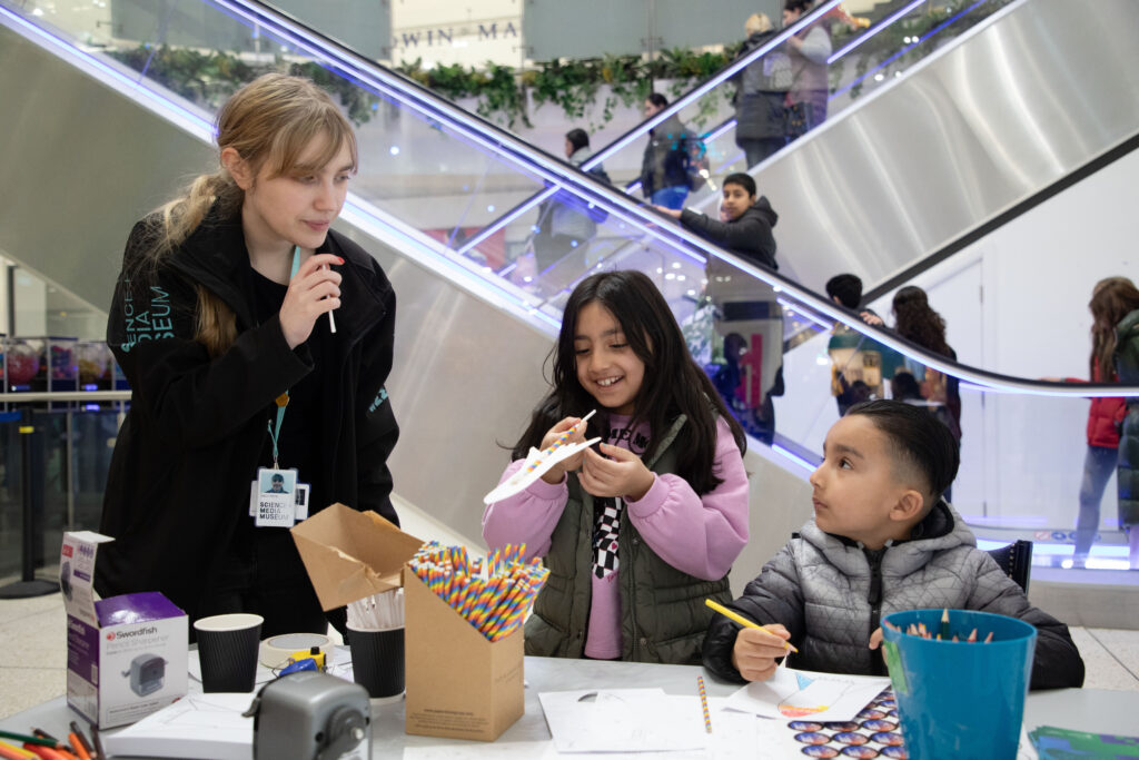 An explainer shows to young children how to make a straw rocket.