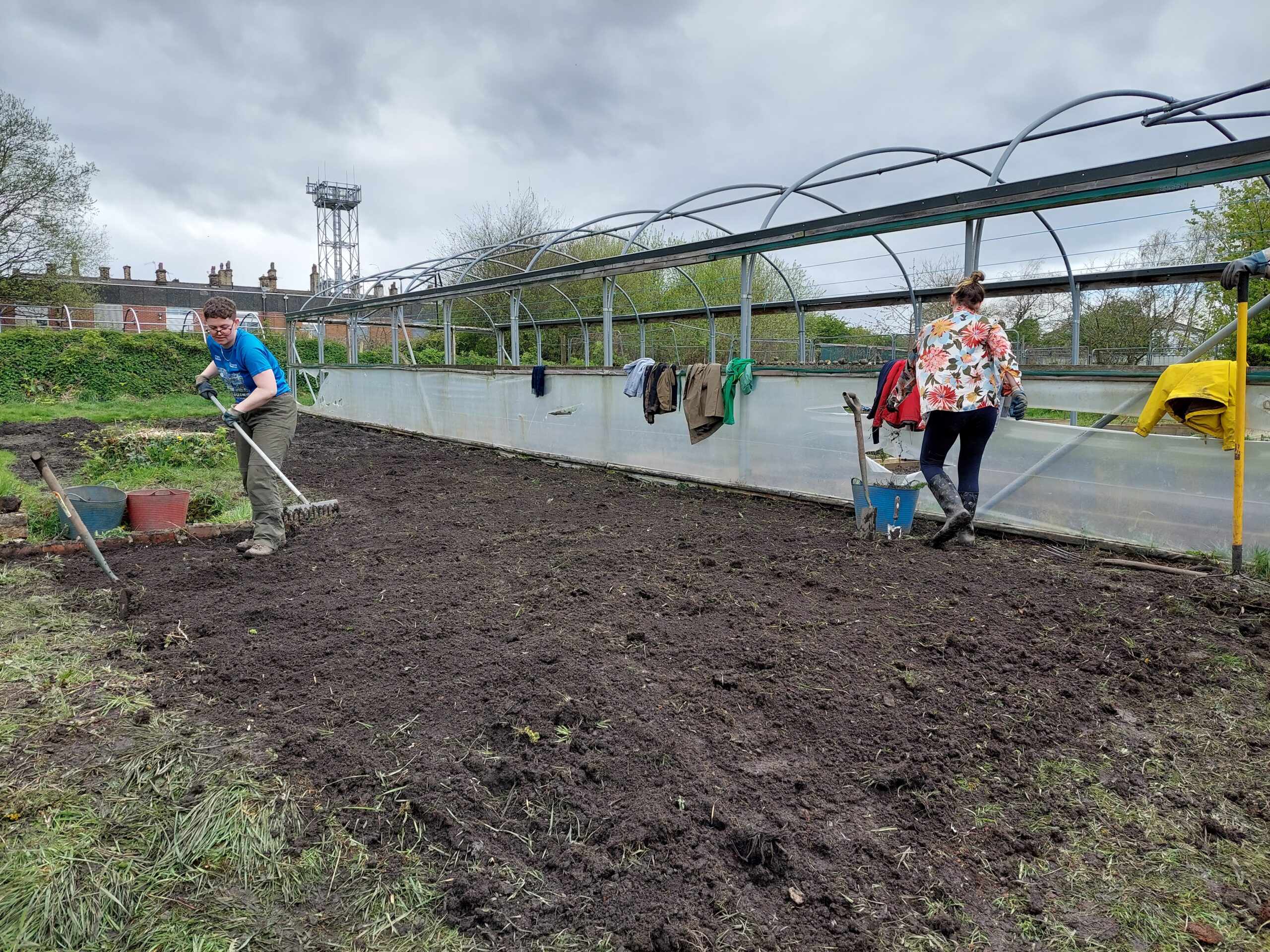 Two people working on a freshly dug patch of earth