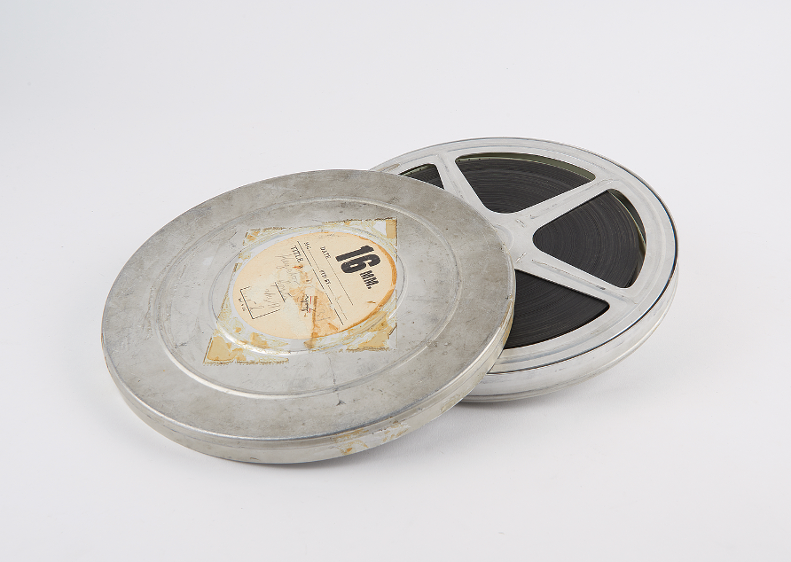 A metal film reel in its circular tin