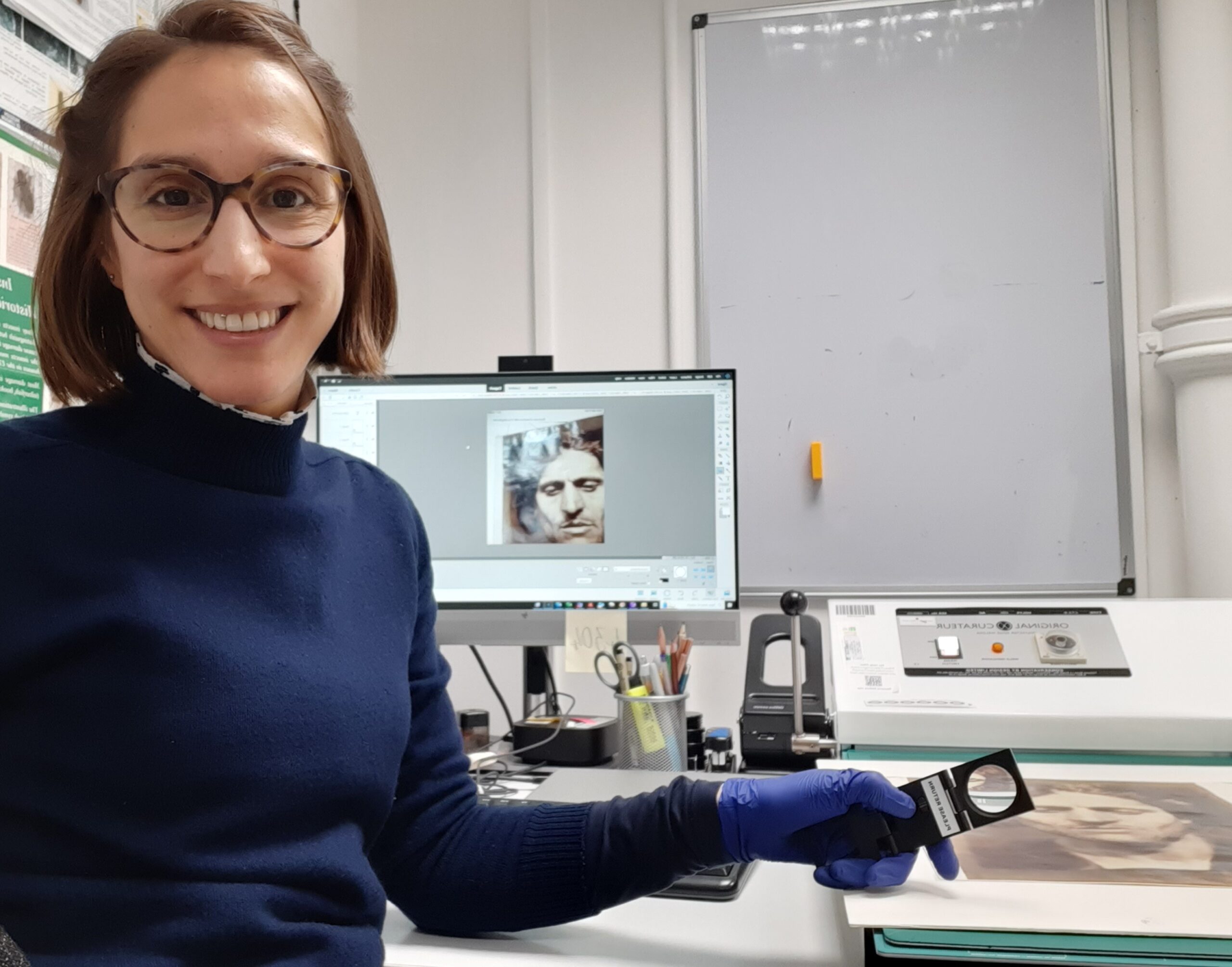 Vanessa sits at her workbench in the conservation lab