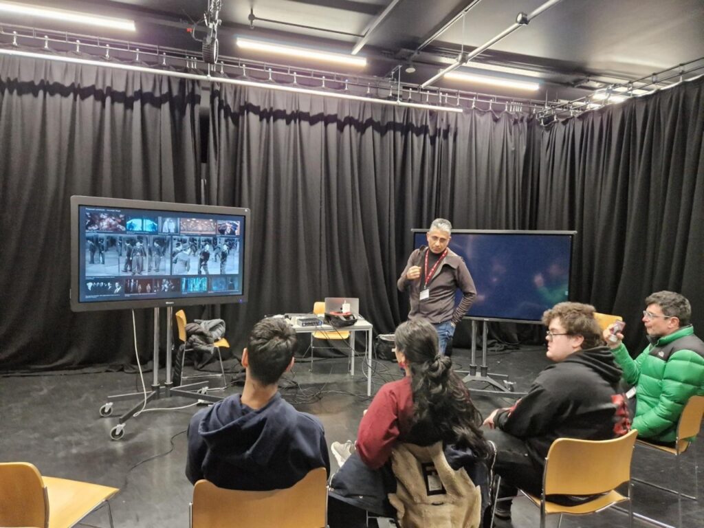 The youth forum listening to a presentation in a studio theatre space