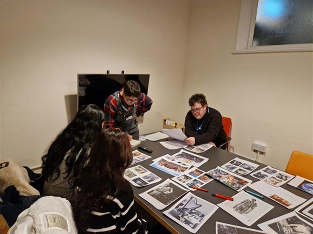 Youth forum members look at lots of images spread out on a table