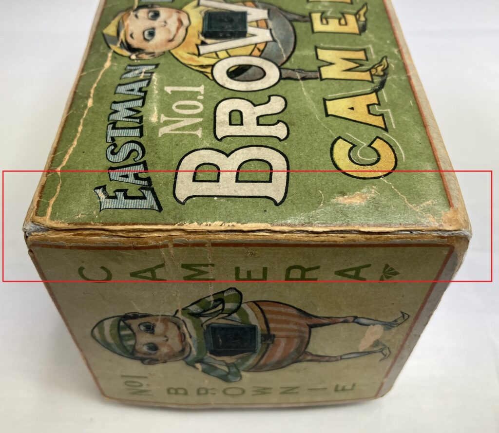 old card camera box with a red outline showing the most flaky and damaged area.