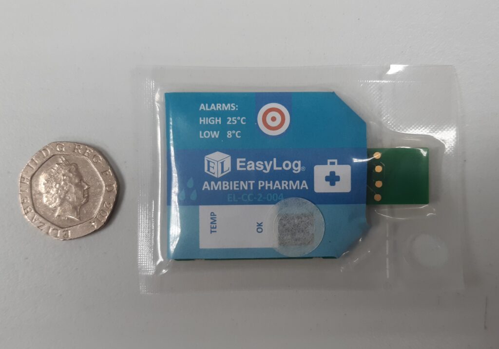 Blue data logger strip next to a 20 pence for scale