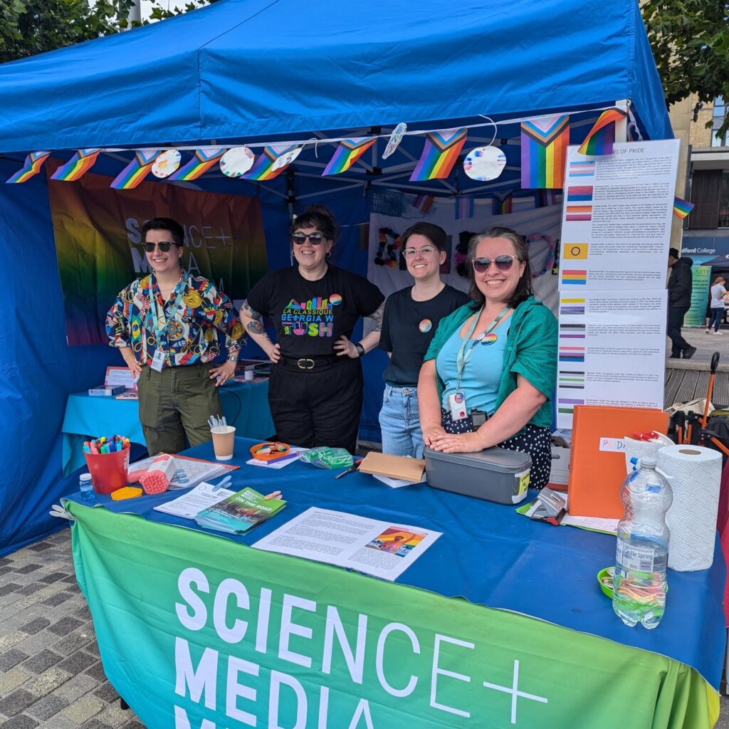 Four museum colleagues at a colourful stall.