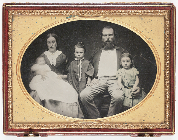 Old photograph of two adults and three children, in an oval frame