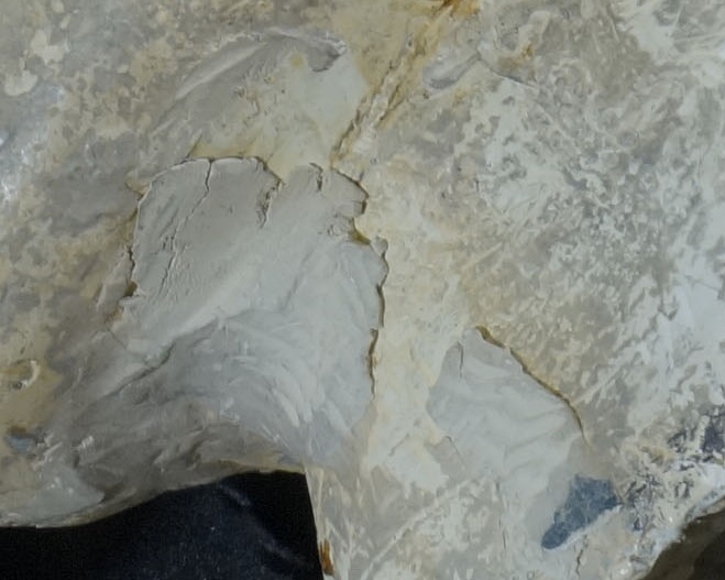 Close-up of the neck of the cast, with material peeling away.