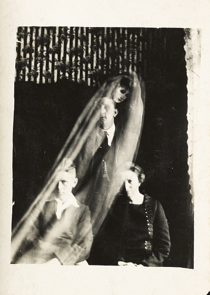 Group of three people with a blurry woman hovering above them.
