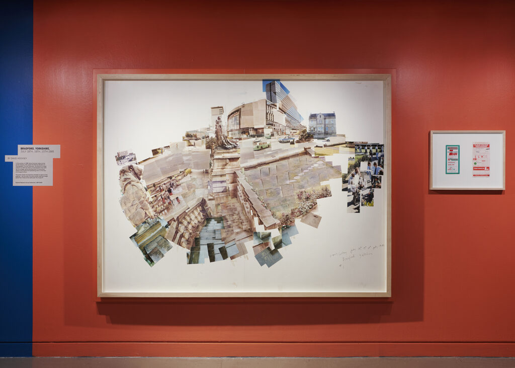 A large framed Hockney photocollage on a red wall.