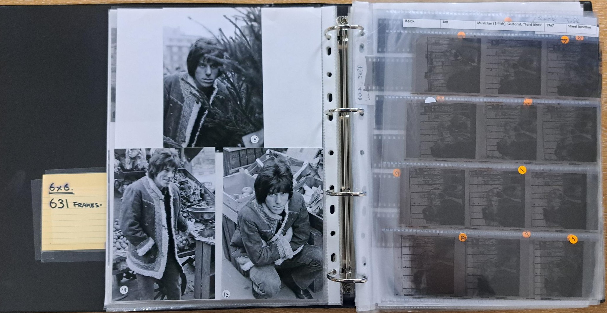 A ringbinder open showing plastic sleeves filled with photographic prints and negatives