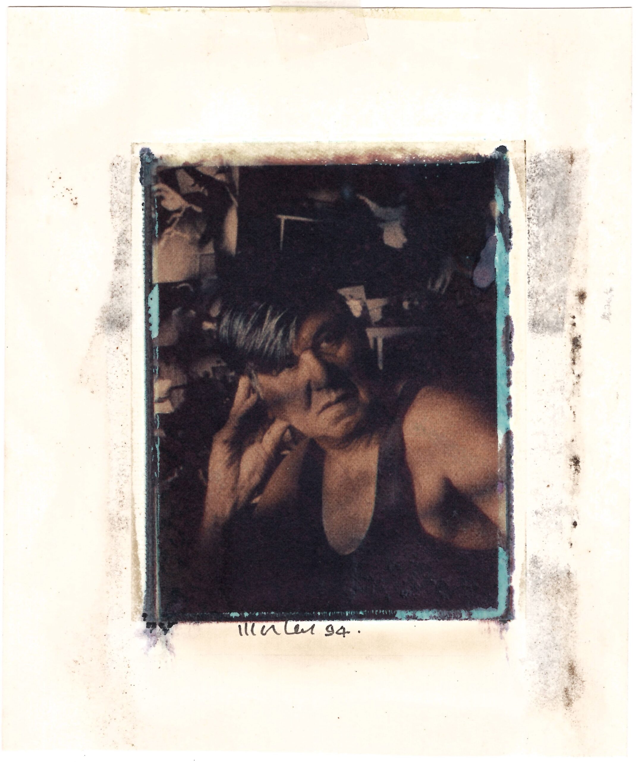 A dark, moody image of Lewis Morley wearing a vest and looking past the camera