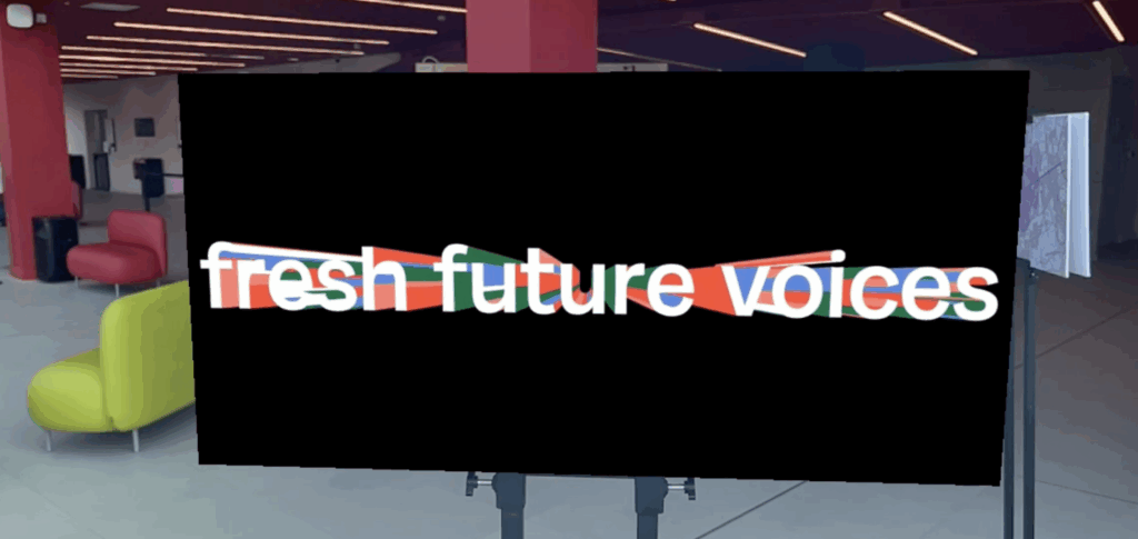 A large screen in the museum foyer displaying word art which reads "fresh future voices"