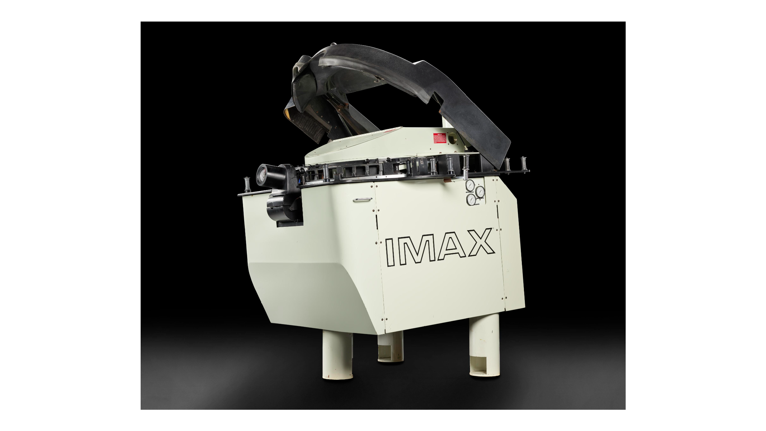 A white box-shaped cinema projector with three short legs and the lid open