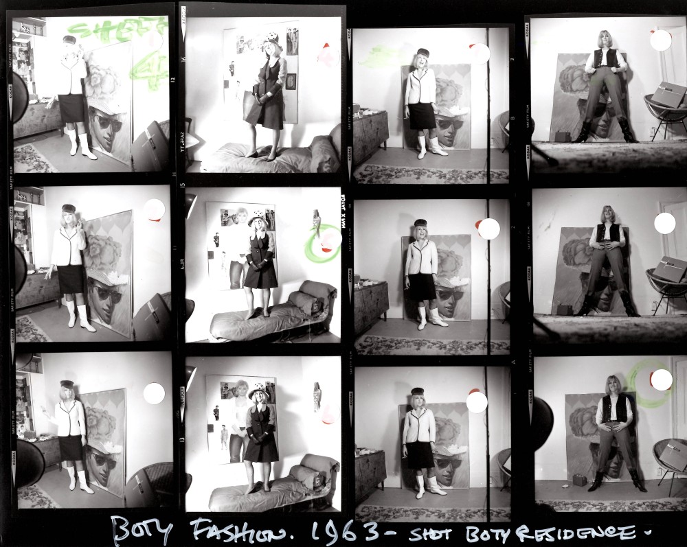 Pauline variously standing on a bed and on the floor in front of paintings leant against the wall