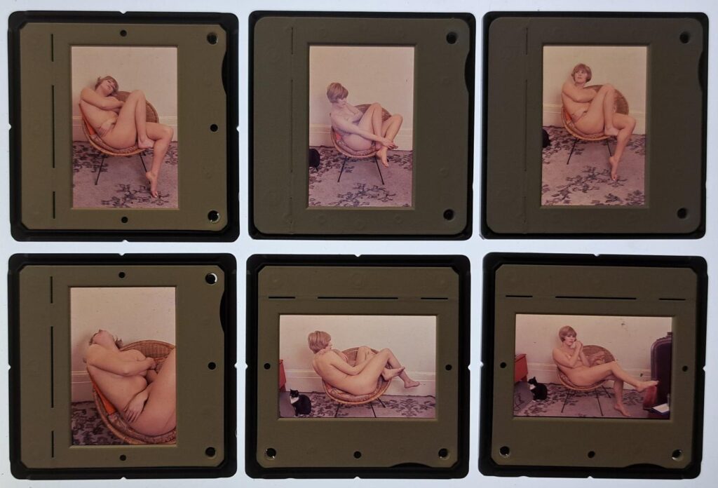 Six colour slides; Pauline poses nude in a basket chair on a floral carpet