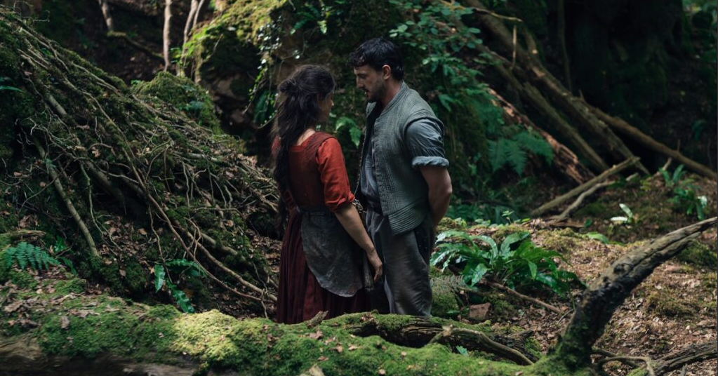 Jessie Buckley and Paul Mescale stand together in a forest in Hamnet