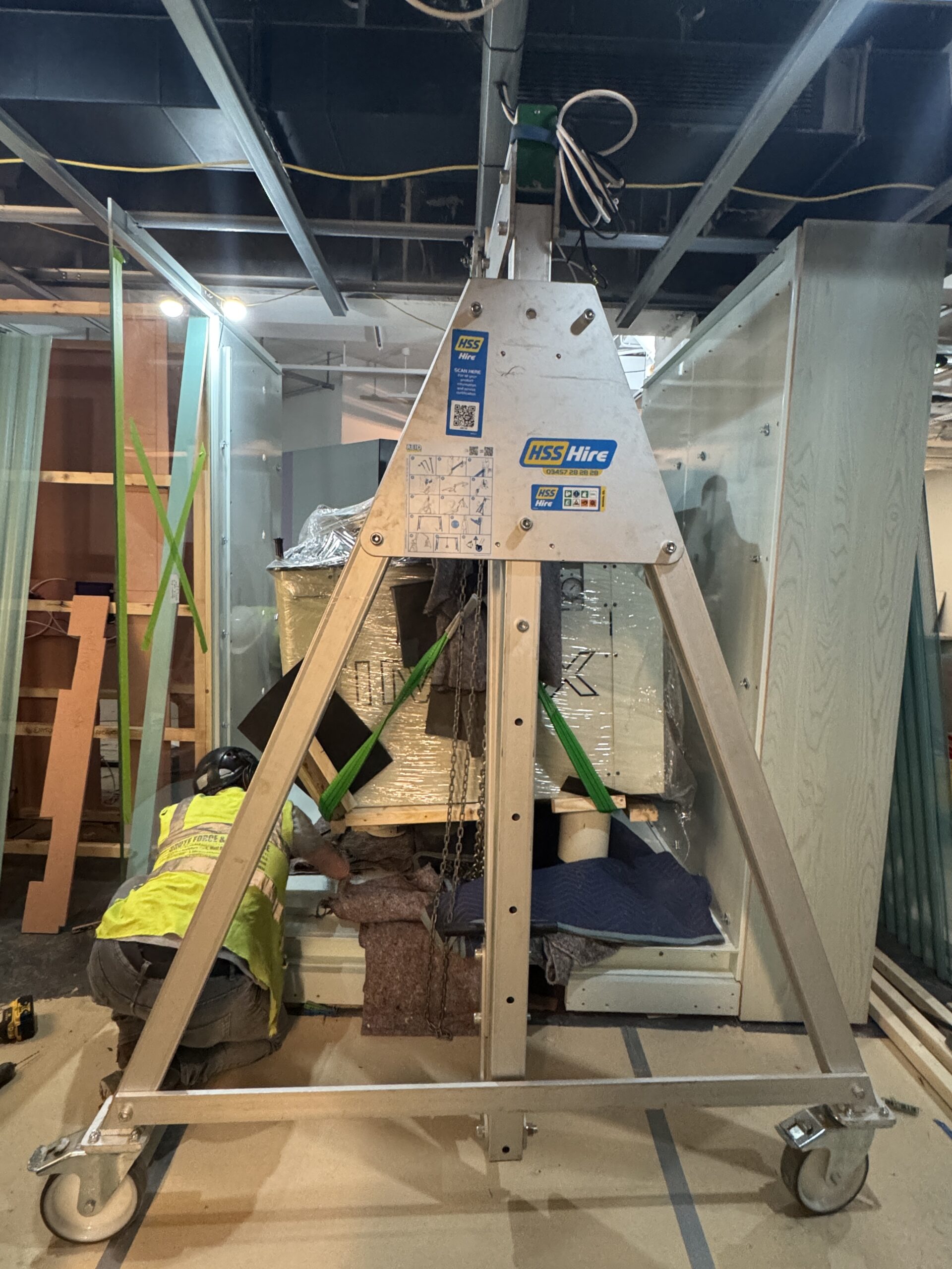 Staff in hi vis moving the projector, which has blankets underneath to prevent damage