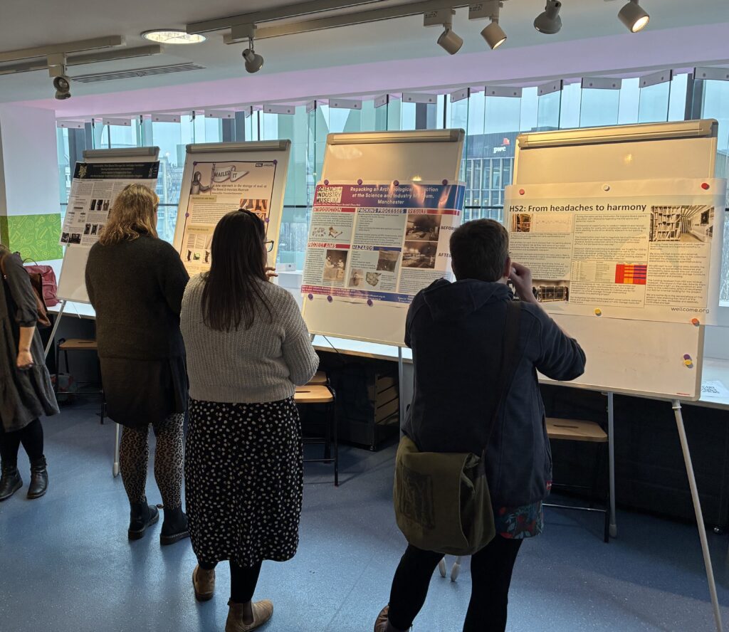 Attendees browse the posters on different conservation themes displayed on flipchart stands by the room's windows