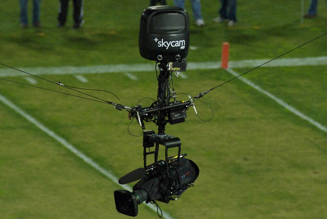 A television camera suspended by cables over a sports pitch