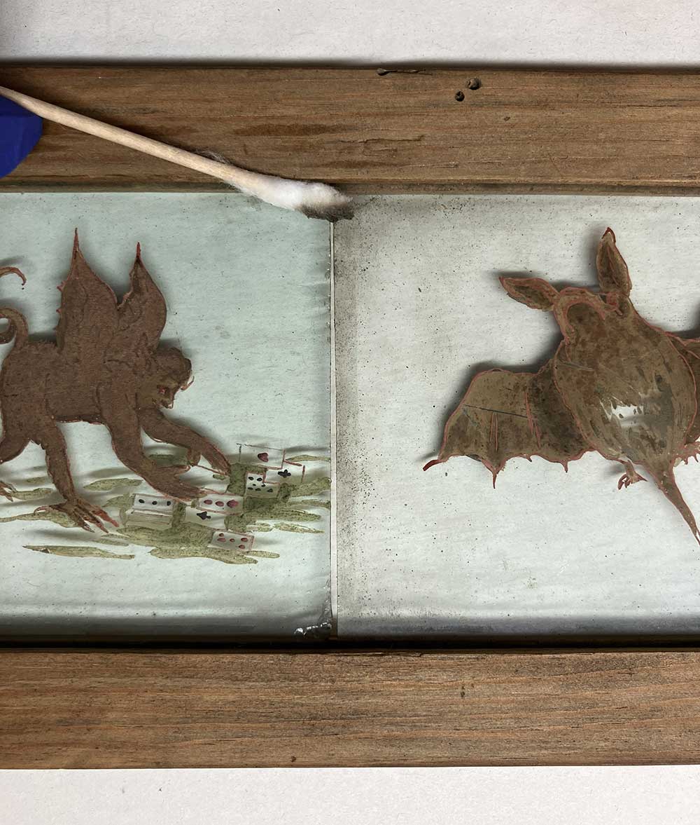 Magic lantern slides with visible surface dirt. A dirty cotton bud is visible in the top corner.