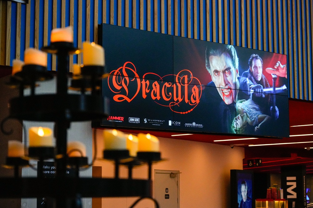 The poster for Christopher Lee's Dracula on the large digital screens in the museum foyer
